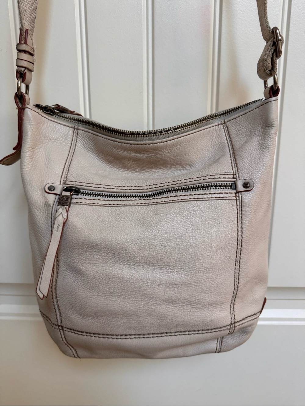 The Sak cream leather cross body bag. 12” by 12” by 2”. max strap drop 24”